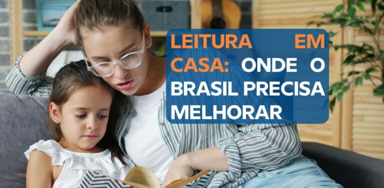Mulher e menina de cerca de cinco anos sentadas no sofá, olhando juntas para o mesmo livro ilustrado aberto.
